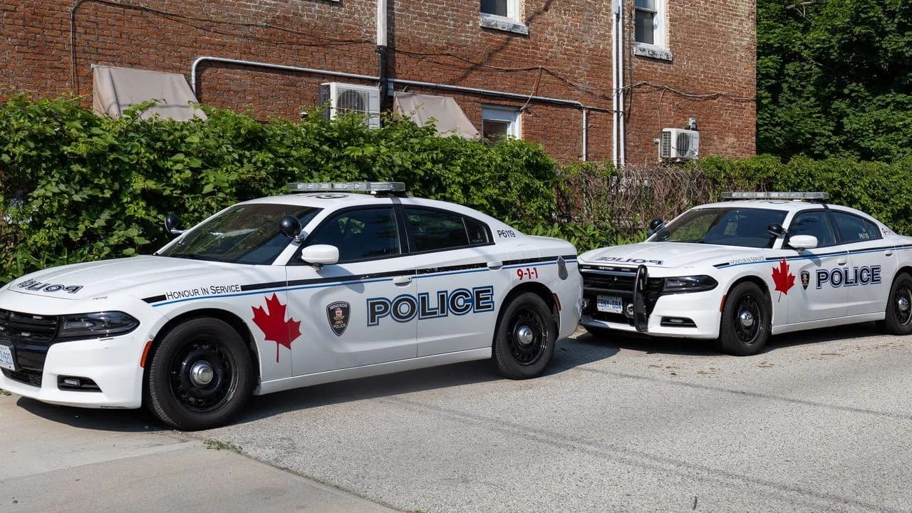 Two white police patrol cars parked side by side in Ontario, Canada; no people visible.