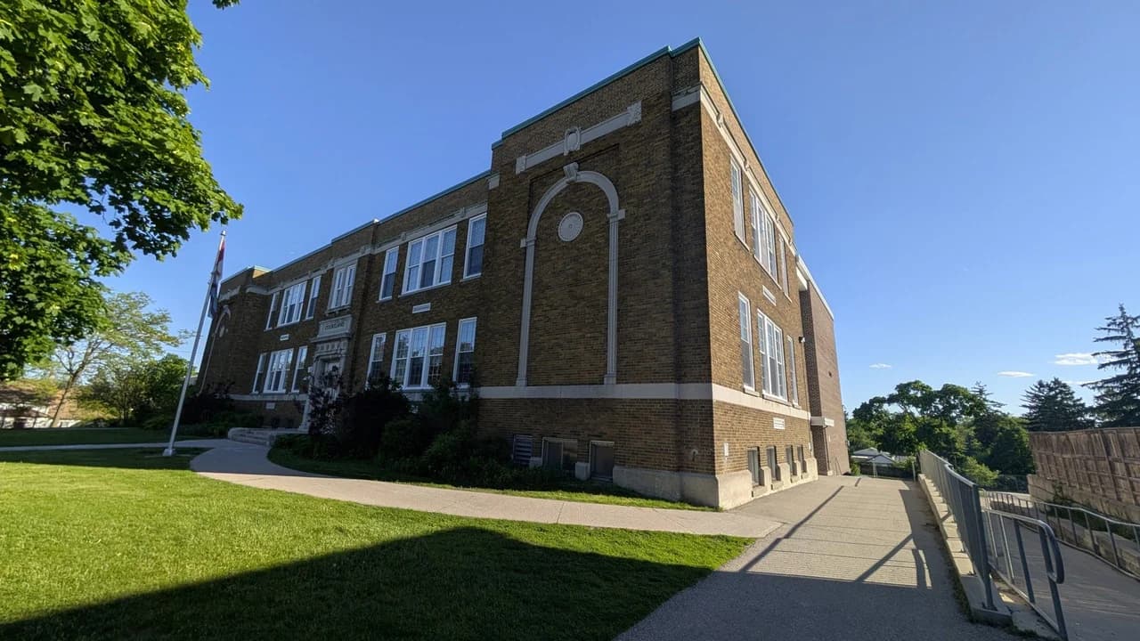 Courtland Avenue Public School, a brick elementary school building in Kitchener, Ontario, on a sunny day; no people visible.
